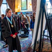 Faculty getting assistance with gowns